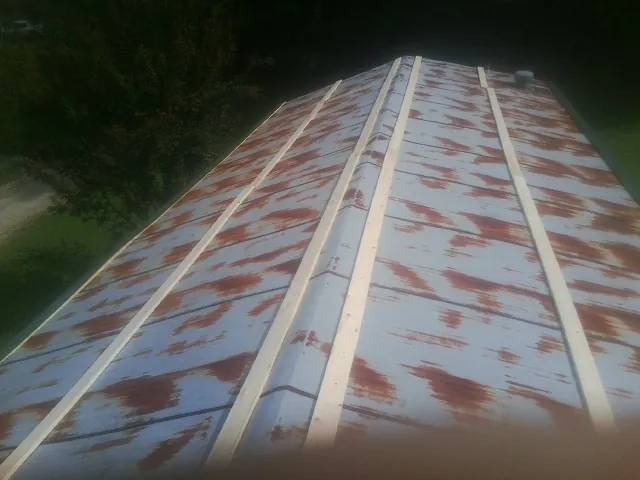 Rusted metal roof panels with new wood purlins before replacement — Storm Damage Roof Repair in Hampton Falls by Roofing Brothers
