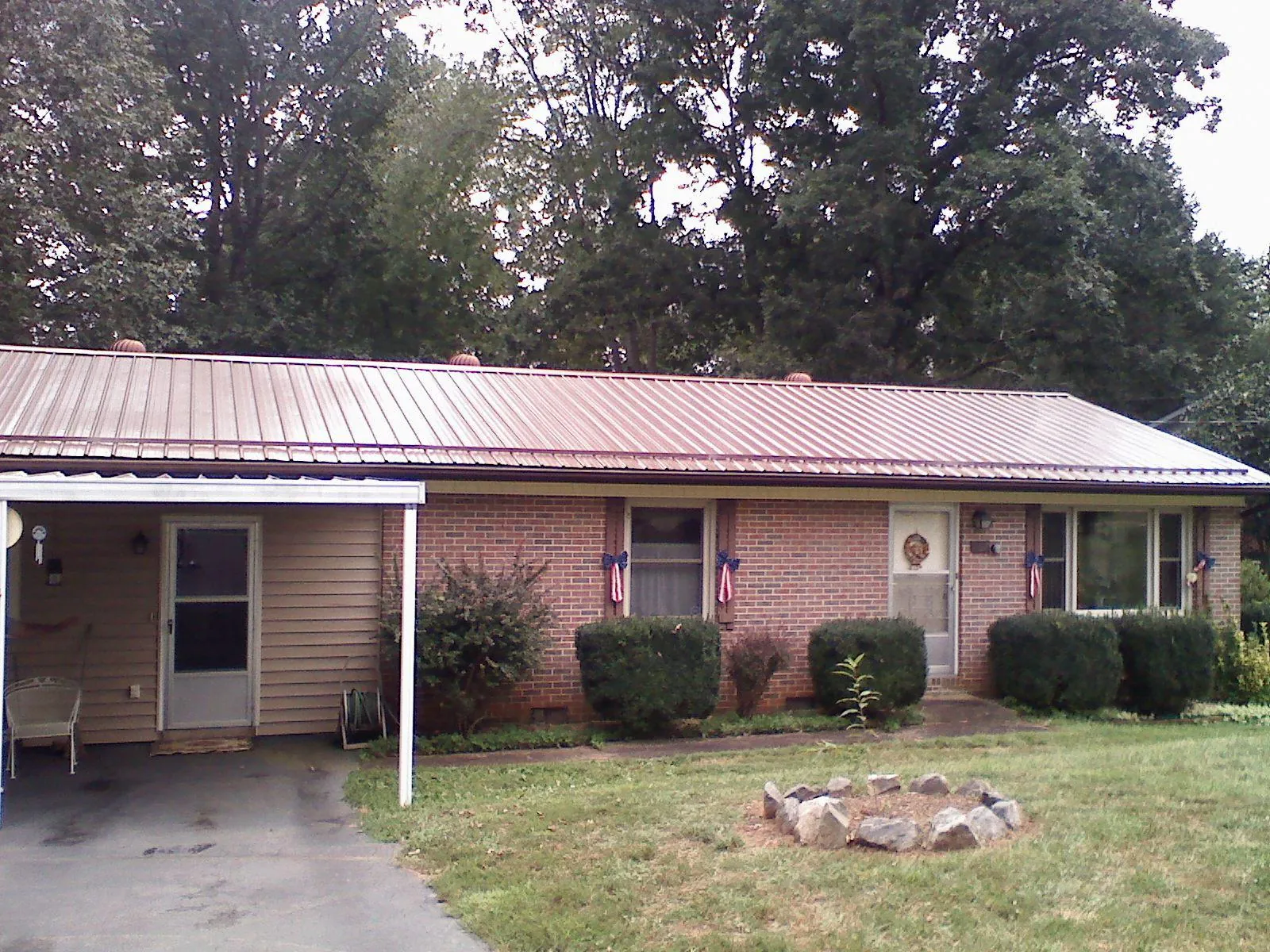 Bronze metal roof and carport on a brick ranch home — Roof Repair work by our crew in Hampton Falls